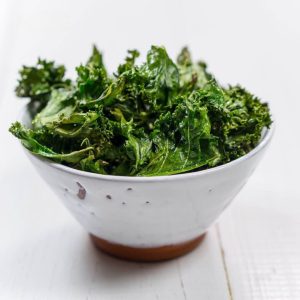 White strainer filled with fresh kale. 