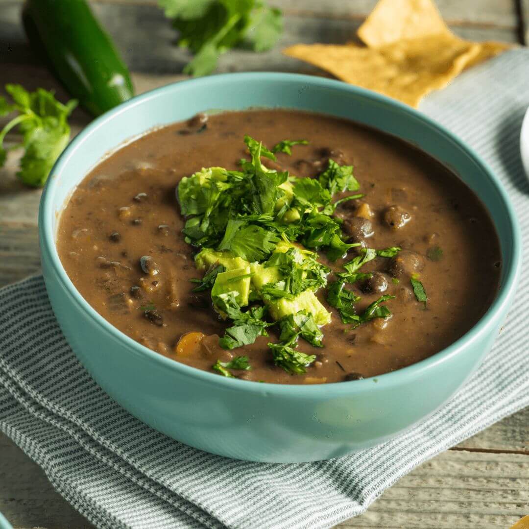 Spicy black bean soup topped with avocado.