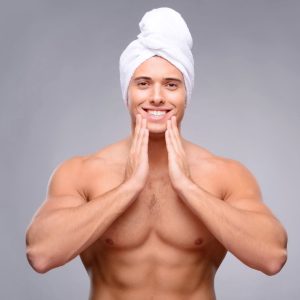 Guy touching wearing a towel on his head. 