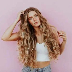 A young woman with long blonde curly hair.